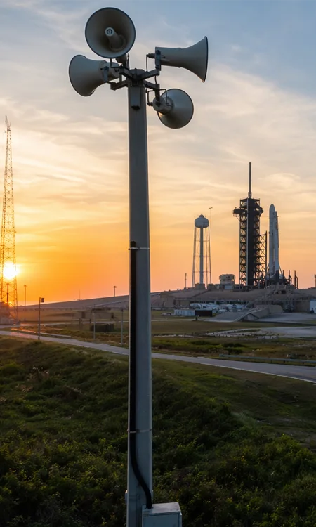 Public-address speaker infrastructure mounted within an industrial launch-support environment.