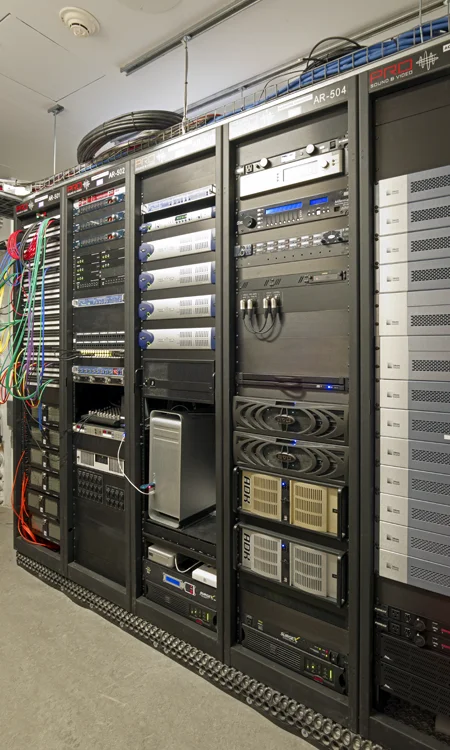 Integrated AV Equipment Racks Supporting New World Symphony Technology Infrastructure Professional AV equipment racks with audio processing, network distribution, signal routing, and system control hardware supporting a performing arts venue.
