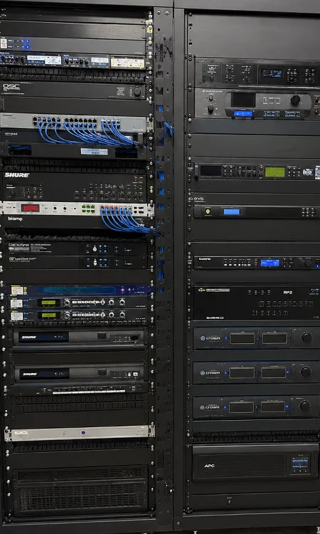 AV equipment rack room showing organized audio, control, network, and power infrastructure supporting a connected venue system