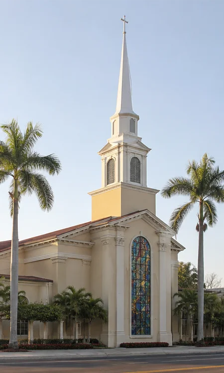 FBC Fort Lauderdale Church Exterior Exterior view of FBC Fort Lauderdale church campus at sunrise featuring a traditional steeple, stained glass window, and palm-lined streetscape