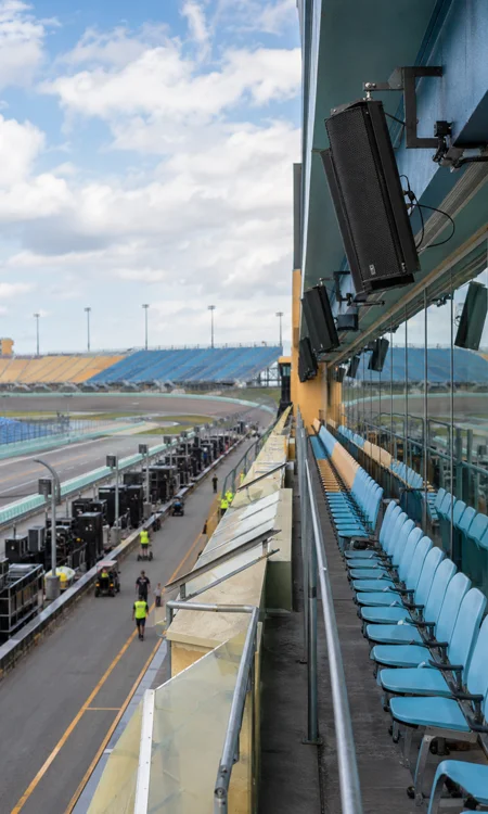 Grandstand Audio Coverage Speedway grandstands with integrated loudspeakers positioned for race-day audio coverage.