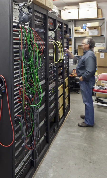 Ohio Stadium Audio Equipment Rack Integration Technician working beside audio equipment racks and cabling for the Ohio Stadium sound system expansion.